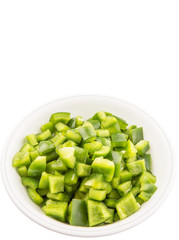 Chopped green capsicums in white bowls over white background 