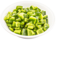 Chopped green capsicums in white bowls over white background 