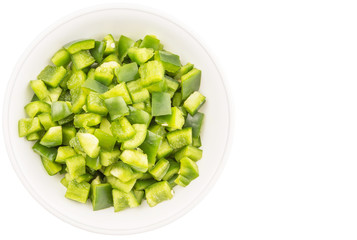Chopped green capsicums in white bowls over white background 