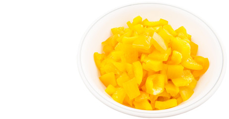 Chopped yellow capsicums in white bowls over white background