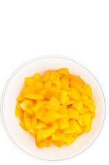 Chopped yellow capsicums in white bowls over white background