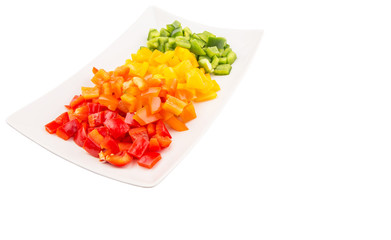 Colorful chopped capsicums in a plate over white background 