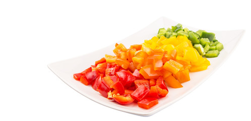 Colorful chopped capsicums in a plate over white background 