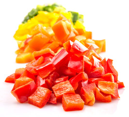 Heaps of chopped colorful capsicums over white background