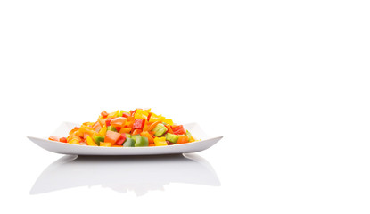 Mix colorful chopped capsicums in a plate over white background