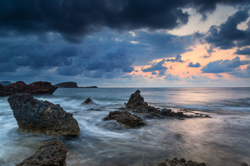 Stunning landscapedawn sunrise with rocky coastline and long exp