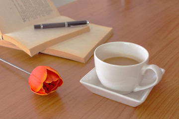 cup of coffee with tulip and book