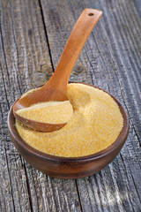 corn grits polenta in a wooden bowl on old wooden table