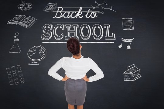 Composite image of businesswoman with hands on hips