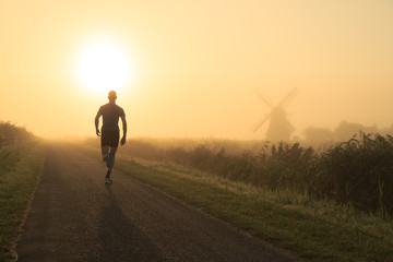 Man running in the foggy countryside