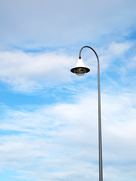 Outdoor public lighting pole with blue sky on background