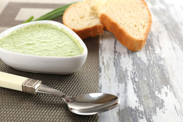 Bowl of broccoli soup on table