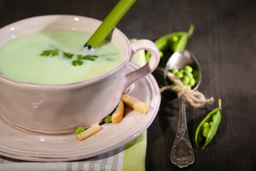 Tasty peas soup on wooden table with dark light