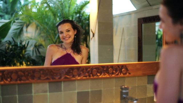 Beautiful elegant woman smiling in the mirror