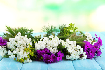 Obraz na płótnie Canvas Flower wreath on table on nature background