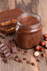 Sweet chocolate cream in jar on table close-up