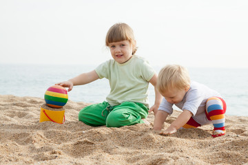 children playing with sand at sea