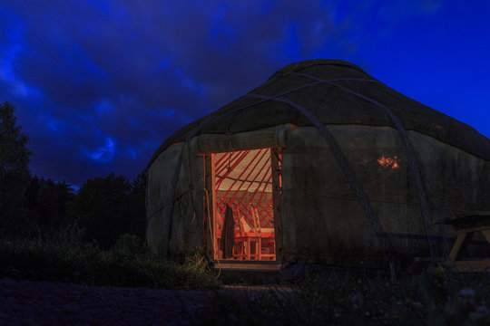 Licht scheint nachts aus der offenen Türe einer kirgisischen Jurte im Biosphärengebiet schwäbische Alb bei Münsingen in Deutschland