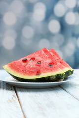 Fresh slices of watermelon on table, on bright background