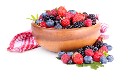 Ripe sweet different berries in wooden bowl, isolated on white