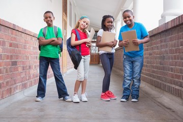 Cute pupils smiling at camera in hallway