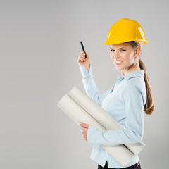 Young female architect holding blueprint and ballpoint