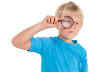 Cute little boy looking through magnifying glass