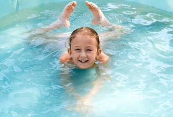 Fototapeta na wymiar the child swims in the pool