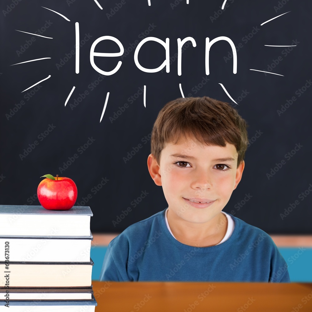 Poster learn against red apple on pile of books in classroom