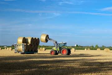 Traktor beim aufladen von Strohballen