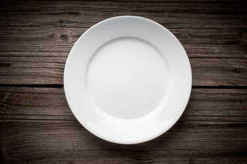 Empty white plate on wooden table