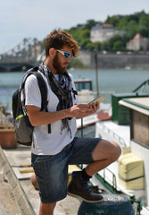 Fototapeta premium young bearded tourist man with backpack and city map