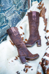 suede boots are on the skin near the fireplace