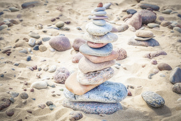 Fototapeta na wymiar Balanced stones stacked in pile on a sand