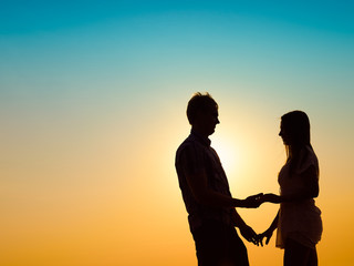 Obraz na płótnie Canvas Young couple and sunset
