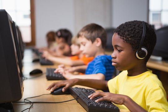 Cute mixed race pupils in computer class