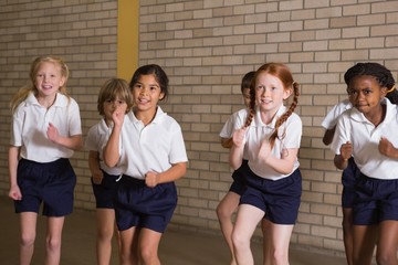 Cute pupils warming up in PE uniform - obrazy, fototapety, plakaty