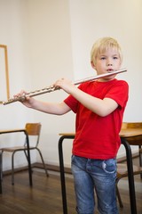 Cute pupil playing flute in classroom © WavebreakMediaMicro