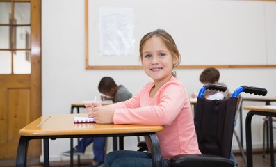 Disabled pupil smiling at camera in classroom