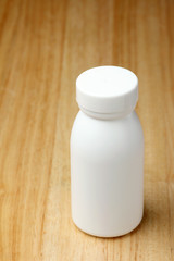 white bottle on the wood table