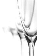 Empty champagne glasses in a row; white background; B&W