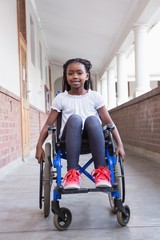 Cute disabled pupil smiling at camera in hall