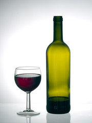 Finishing the bottle. Red wine glass and bottle.