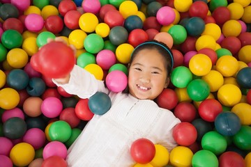 Fototapeta na wymiar Happy girl playing in ball pool