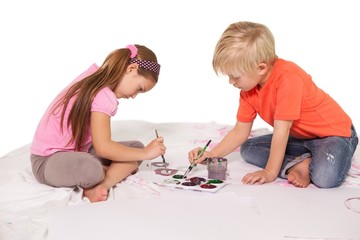 Happy little children painting on the floor