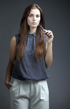 Elegant, beautiful woman smoking e-cigarette