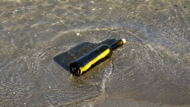 secret message inside a bottle on the sandy sea shore
