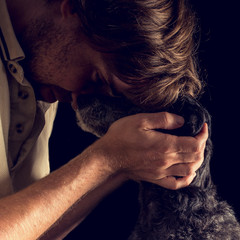 Loving man hugging his terrier dog