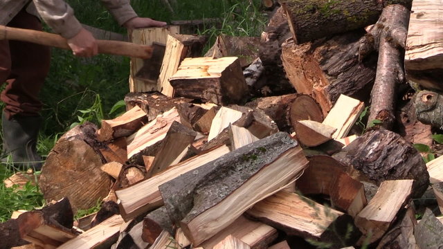 Peasant worker man chop wood nead firewood pile. Closeup
