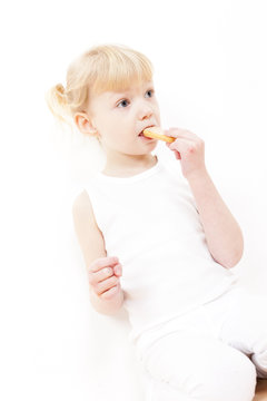 portrait of little girl eating buscuit